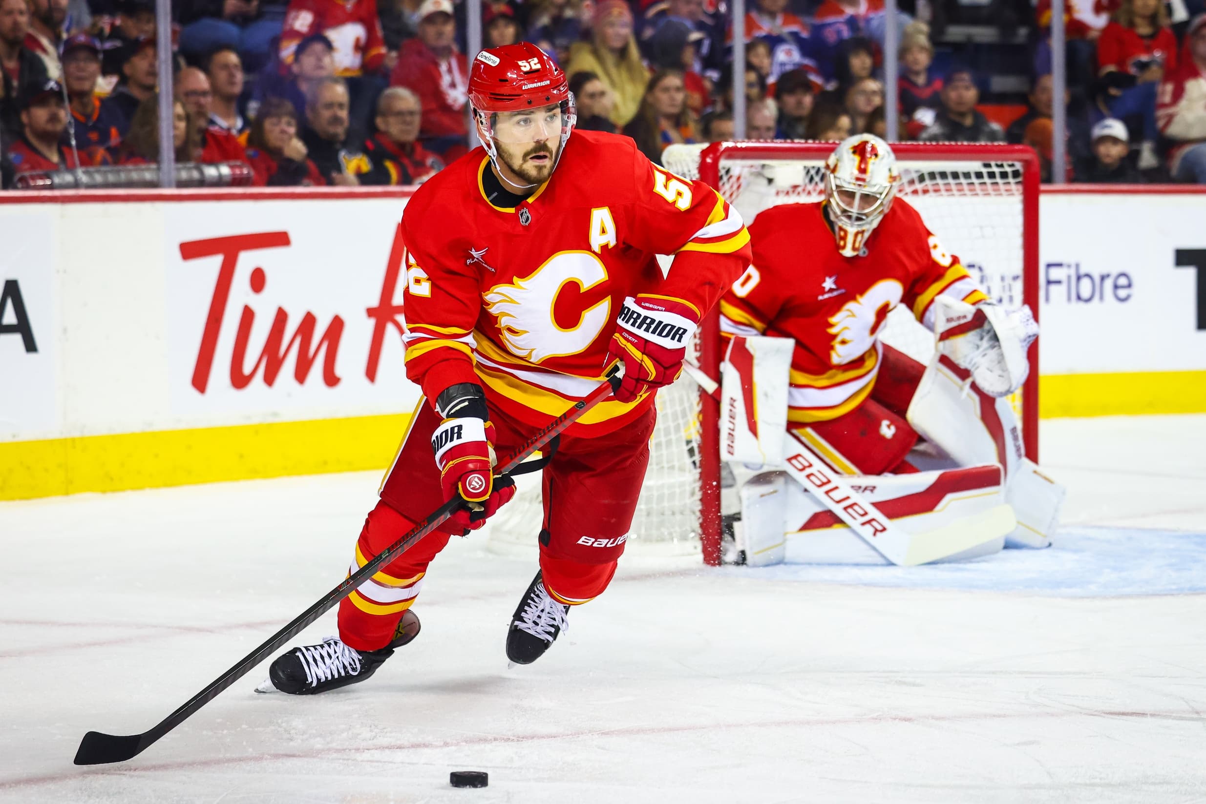 Calgary Flames defenseman MacKenzie Weegar (52) controls the puck against the Edmonton Oilers during the first period at Scotiabank Saddledome.
