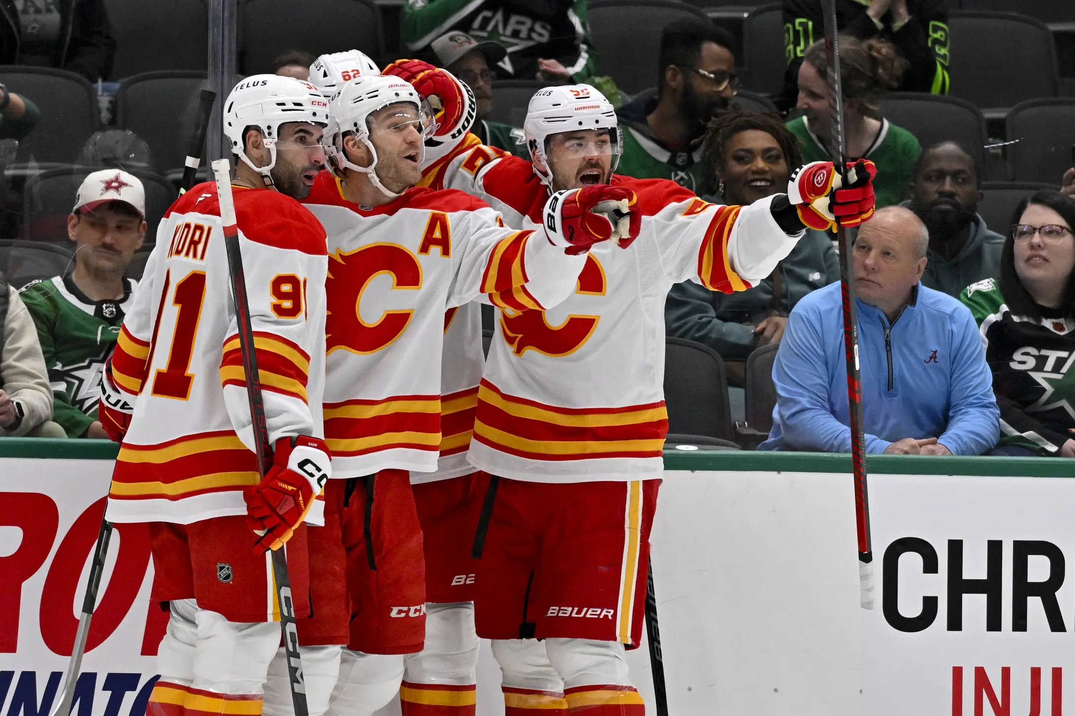 Calgary Flames center Nazem Kadri (91) and center Jonathan Huberdeau (10) and defenseman Daniil Miromanov (62) and defenseman MacKenzie Weegar (52) celebrates a goal scored by Huberdeau against the Dallas Stars during the first period at the American Airlines Center.