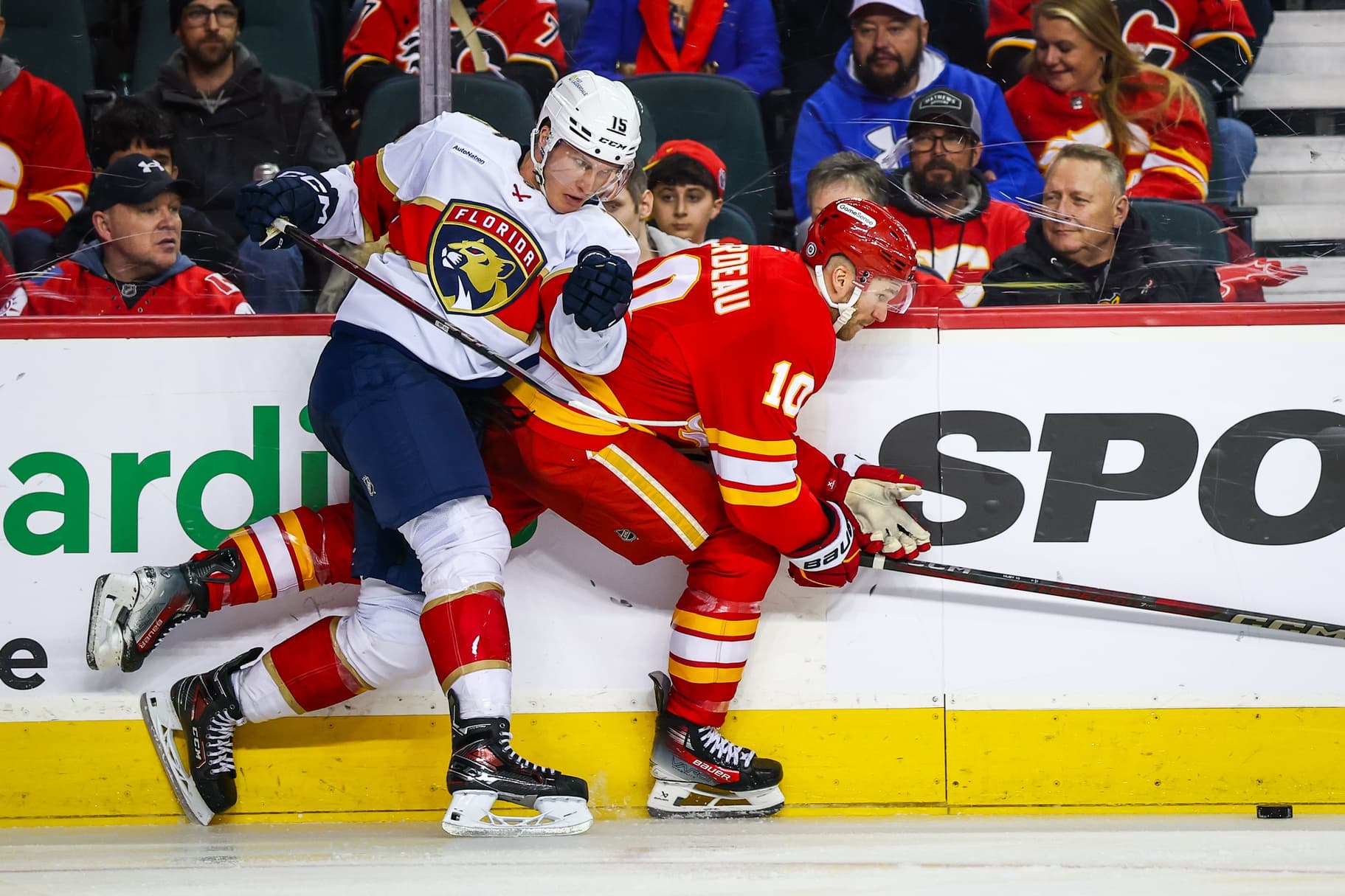 Calgary Flames center Jonathan Huberdeau (10) and Florida Panthers center Anton Lundell (15) battles for the puck during the third period at Scotiabank Saddledome.