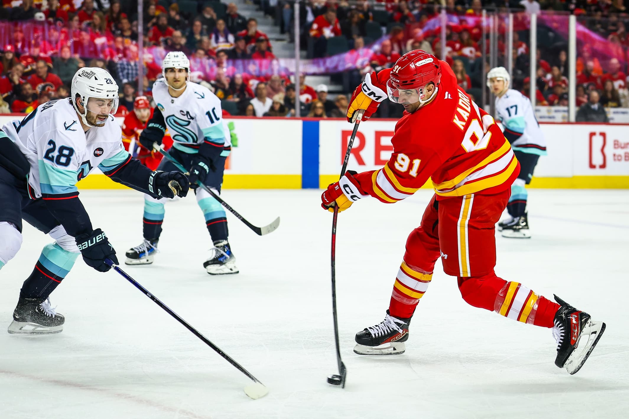 Calgary Flames center Nazem Kadri (91) shoots the puck as Seattle Kraken defenseman Joshua Mahura (28) defends during the second period at Scotiabank Saddledome