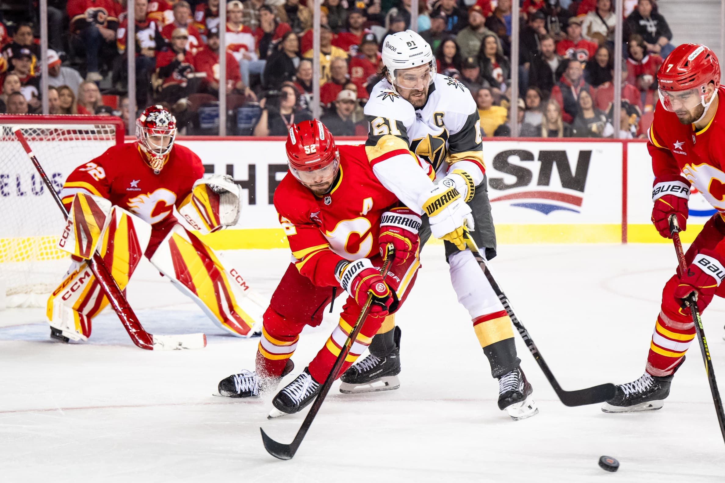 Calgary Flames defenseman MacKenzie Weegar (52) and Vegas Golden Knights right wing Mark Stone (61) compete for the puck during the third period at Scotiabank Saddledome